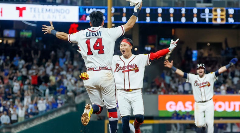 Atlanta Braves left fielder Mauricio Dubón (left) runs to celebrate with teammate Ha-Seong Kim after Kim hit a walk-off single in the ninth inning against the Los Angeles Dodgers at Truist Park in Atlanta on Wednesday, Aug. 26, 2026. The Braves defeated the Dodgers 6-5. (Miguel Martinez/AJC)