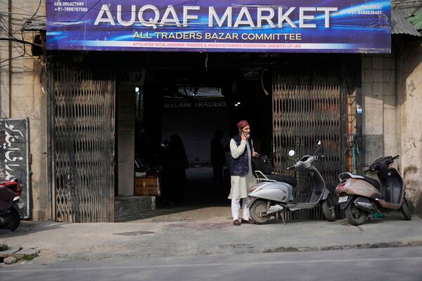 An elderly Kashmiri man talks on his cell phone outside the Auqaf Market in Srinagar, Indian controlled Kashmir, Wednesday, April 2, 2025. (AP Photo/Mukhtar Khan)