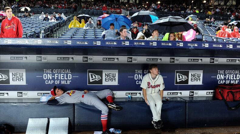 Bat boys wait out a weather-delayed start to the game between the Braves and the Cardinals, Saturday, Oct. 3, 2015, in Atlanta. (AP Photo/John Amis)
