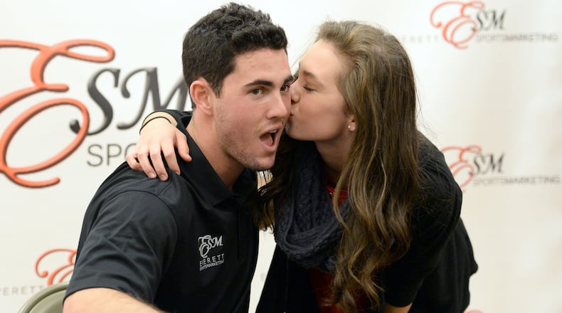 Daughtry St. John, of Columbus, kisses Aaron Murray as they pose for a photographer during his signing event at Georgia Square Mall in Athens on Saturday, December 14, 2013. St. John left home at 6 a.m. today to meet Aaron Murray. St. John had her knee surgery on the same day as Aaron Murray had his knee surgery. Former Georgia quarterback Aaron Murray is signing autographs at the Georgia Square Mall and part of the proceeds will benefit Extra Special People, an organization that enhances the lives of children with developmental disabilities.