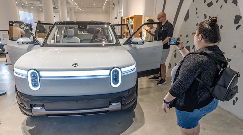 Sabrina Eijan takes a photograph of the new Rivian R2 prototype that will eventually be made in Georgia at the Ponce City Market in Atlanta on April 27, 2024.  (Steve Schaefer/AJC)