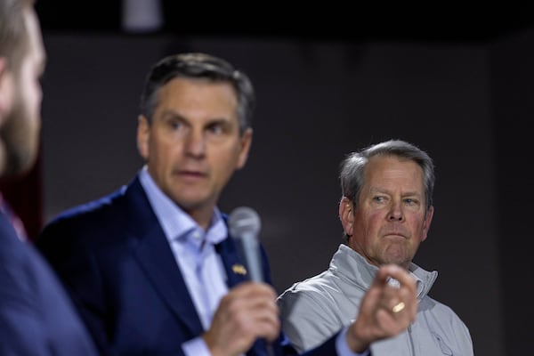 Georgia Gov. Brian Kemp, right, listens as Derek Dooley, left, a Republican candidate for Senate in Georgia, speaks during an Atlanta Young Republicans campaign event last month. (Alyssa Pointer/AP)