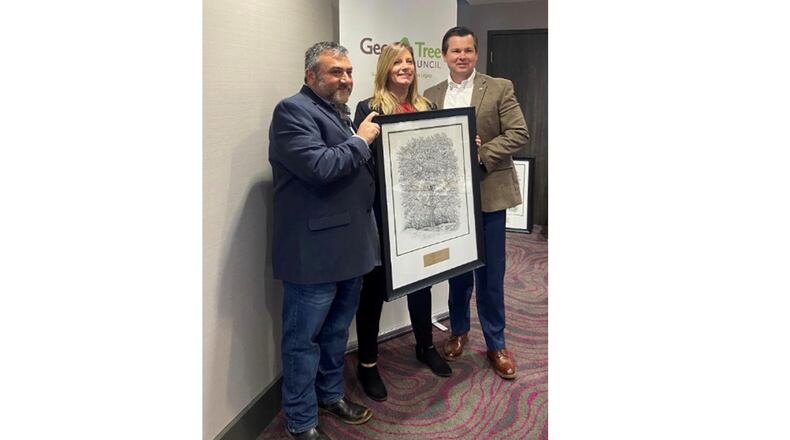 Milton arborist Sandra DeWitt is holding the city's Georgia Tree Council Outstanding New Initiative Grand Award, which will soon hang at City Hall flanked by Georgia Tree Council President (and Alpharetta City Arborist) David Shostak to her left and Georgia Forestry Commission Director and State Forester Tim Lowrimore to her right. COURTESY CITY OF MILTON