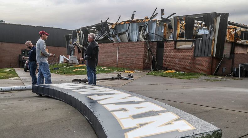 March 26, 2021 Coweta: School officials survey Newnan High School, which sustained heavy damage from a tornado early Friday. Daylight gave emergency crews a look at the damage, summed up in one word: catastrophic. The city of Newnan, including the historic district and Newnan High School, was hit especially hard. (John Spink / John.Spink@ajc.com)