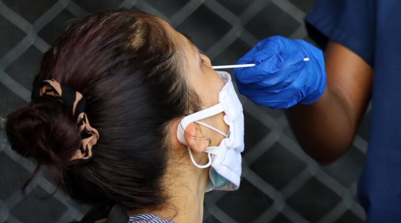 A person gets the swab with the COVID-19 test on her nose during a free test drive on the Good Samaritan Clinic’s parking lot. The Clinic offers free check with the results in 15 minutes on June 23, 2020, in Atlanta. MIGUEL MARTINEZ FOR THE AJC