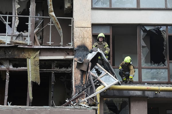 Firefighters work in a destroyed apartment building after a Russian attack in Kyiv, Ukraine, Monday, July 21, 2025. (AP Photo/Efrem Lukatsky)