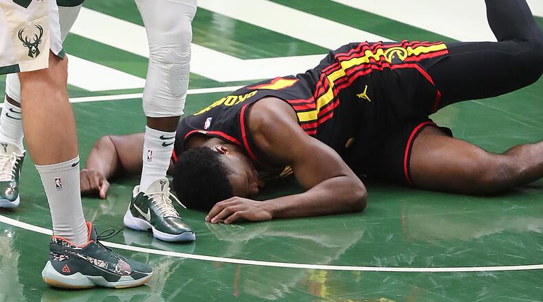 Hawks' Onyeka Okungwu is knocked to the hardwood with a hard foul.   “Curtis Compton / Curtis.Compton@ajc.com”
