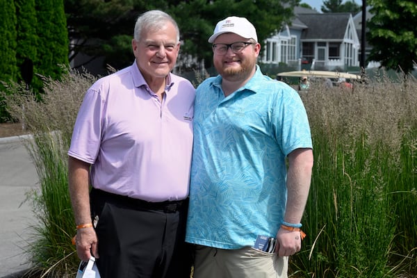 Andy Bessette, left, executive vice president and chief administrative officer for Travelers, and his son Chris Bessette, right, smile during the Travelers Championship golf tournament at TPC River Highlands in Cromwell, Conn., Thursday, June 19, 2025. (AP Photo/Jessica Hill)