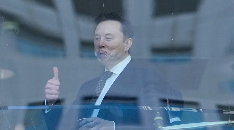 Elon Musk, left, gestures as he walks through a hallway inside the U.S. District Court in Oakland, Calif., Wednesday, April 29, 2026. (AP Photo/Godofredo A. Vásquez)