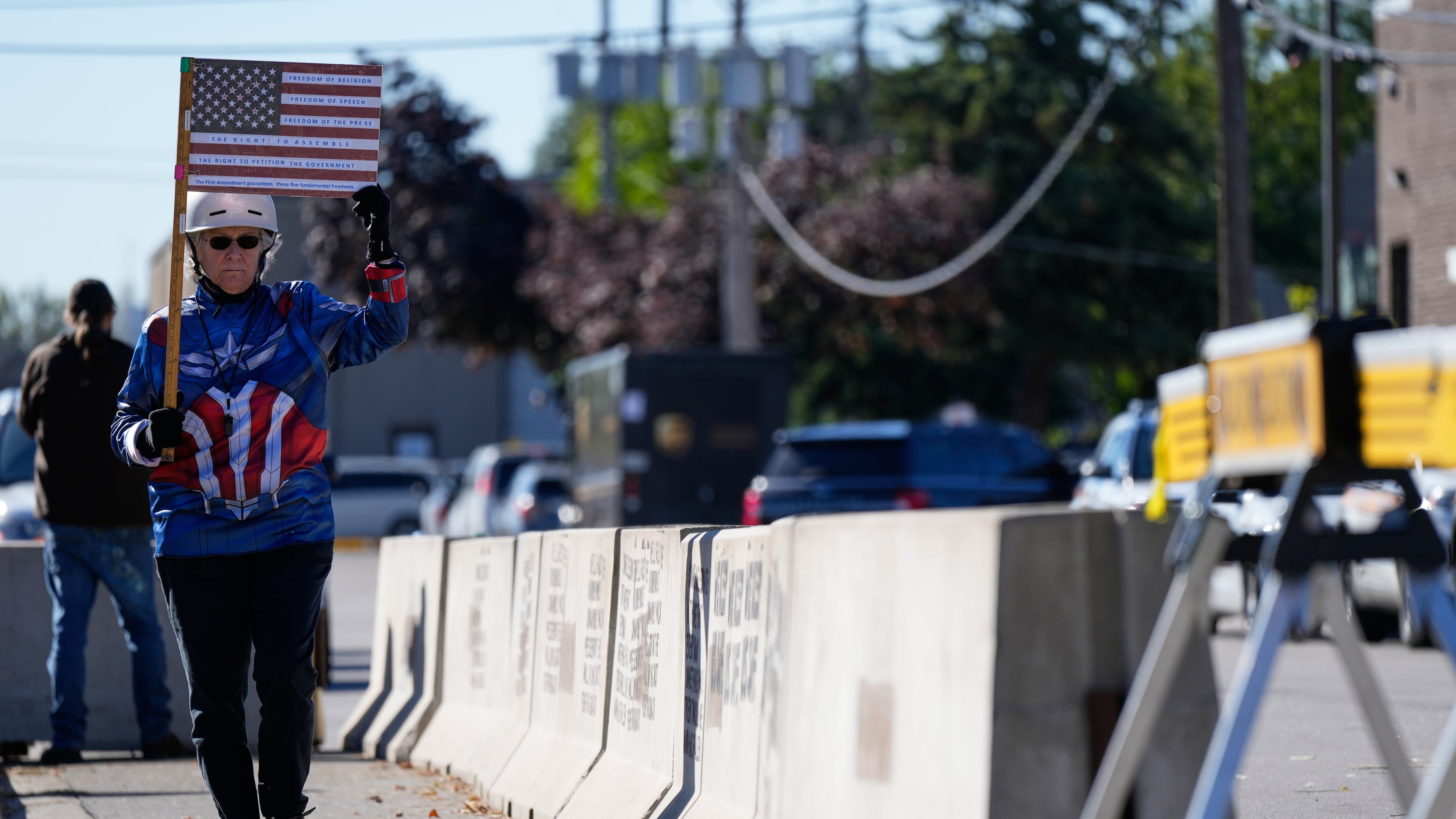 Jeanette Mancusi holds a American flag with the writing outside an ICE (U.S. Immigration and Customs Enforcement) processing facility in the Chicago suburb of Broadview, Ill., Monday, Oct. 20, 2025. (AP Photo/Nam Y. Huh)