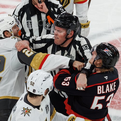 Vegas Golden Knights' Cole Smith (22) and Carolina Hurricanes' Jackson Blake (53) scuffle as an official tries to separate them during the second period of Game 5 of the NHL hockey Stanley Cup Final series in Raleigh, N.C., Thursday, June 11, 2026. (AP Photo/Ben McKeown)