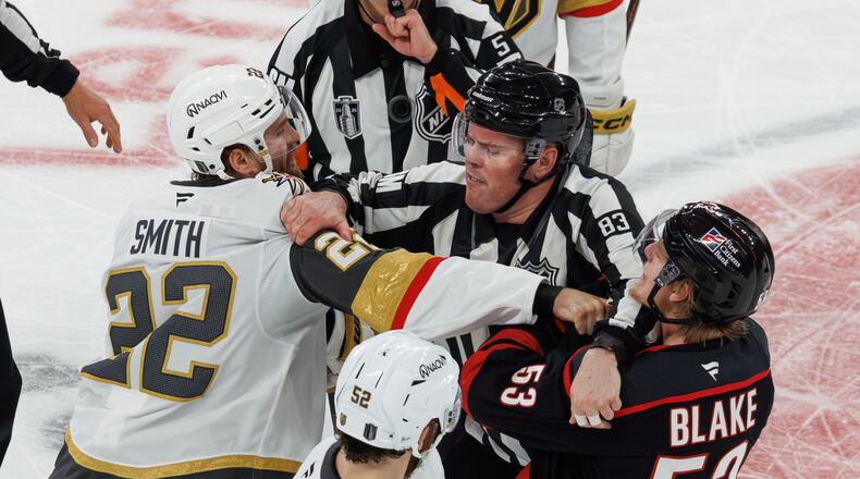 Vegas Golden Knights' Cole Smith (22) and Carolina Hurricanes' Jackson Blake (53) scuffle as an official tries to separate them during the second period of Game 5 of the NHL hockey Stanley Cup Final series in Raleigh, N.C., Thursday, June 11, 2026. (AP Photo/Ben McKeown)