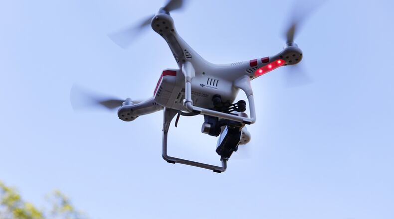 A DJI Phantom 2 drone controlled by drone videographer Curt Walton hovers to shoot aerial video above a multimillion-dollar home for sale in the hills above Saratoga, Calif., on Feb. 25, 2016. Federal aviation regulators issued long-awaited commercial drone rules on Tuesday. (Gary Reyes/Bay Area News Group/TNS)
