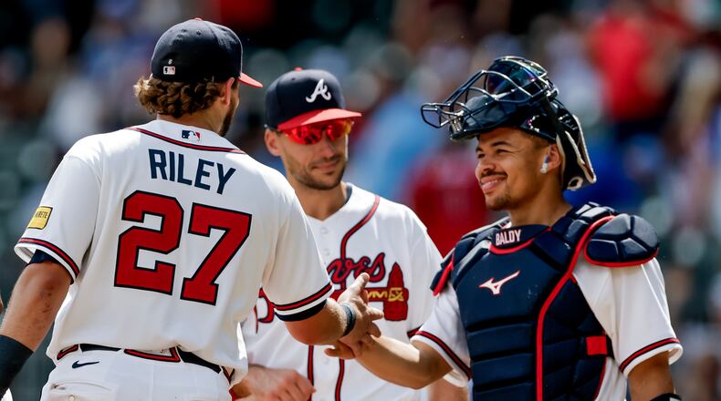 Atlanta Braves third baseman Austin Riley (27) reacts with first baseman Matt Olson, center, and catcher Drake Baldwin, right, after the team defeated the Texas Rangers in a baseball game, Sunday, July 19, 2026, in Atlanta. (AP Photo/Erik S. Lesser)