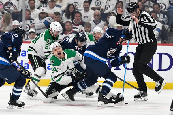 Dallas Stars' Roope Hintz (24) reacts after a face-off against Winnipeg Jets' Morgan Barron (right) during first period NHL playoff hockey action in Winnipeg, Thursday, May 15, 2025. (Fred Greenslade/The Canadian Press via AP)