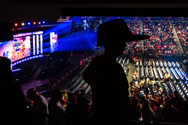A supporter with an oversized hat waits to be seated before presidential candidate Donald Trump’s rally at Gas South Arena in 2024. (Arvin Temkar/AJC)