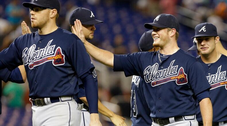 Atlanta Braves relief pitcher Craig Kimbrel, front right, and first baseman Freddie Freeman, left, high-five their teammates after defeating the Miami Marlins 4-3 during a baseball game, Tuesday, Sept. 10, 2013, in Miami. (AP Photo/Lynne Sladky)