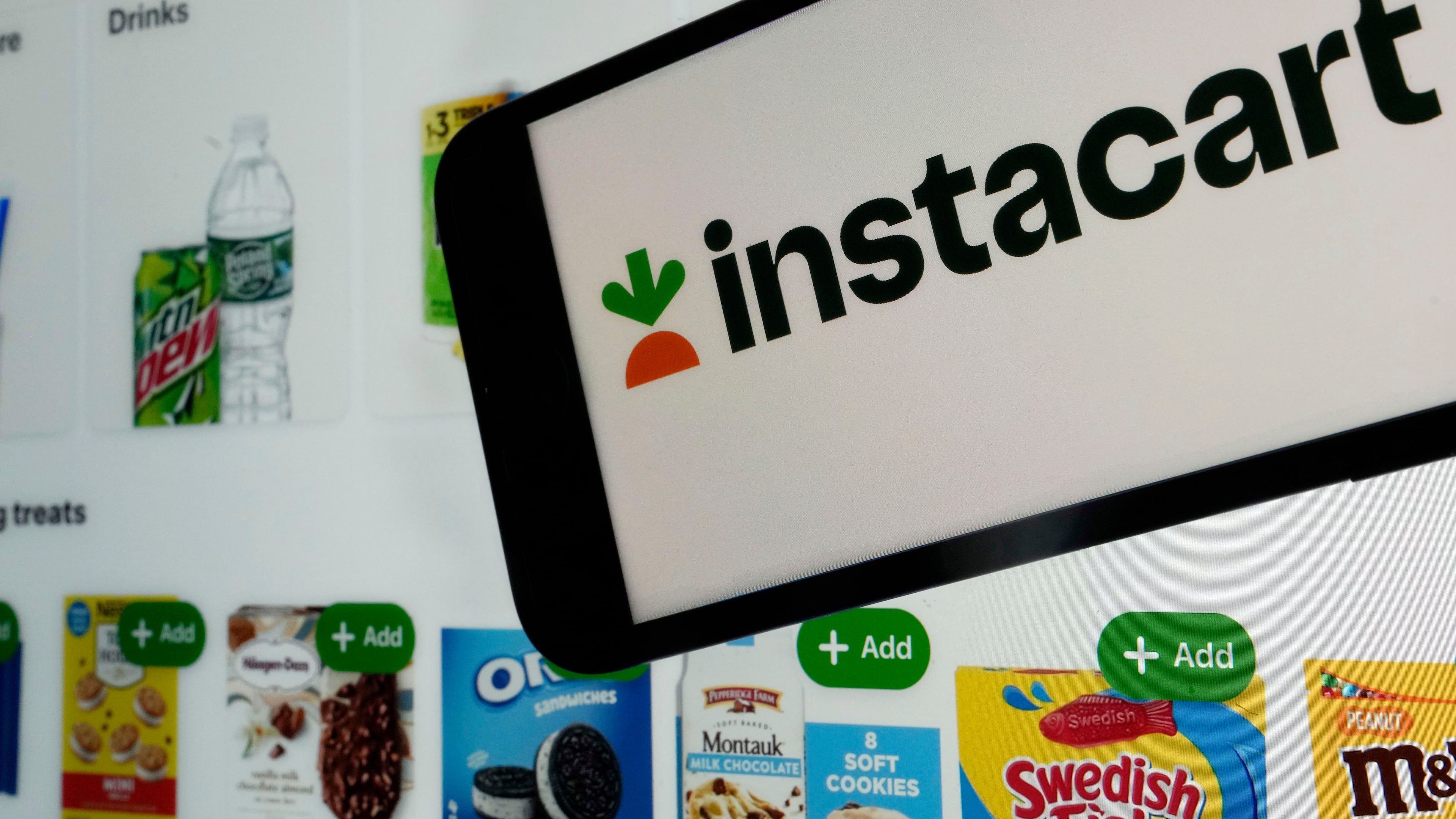 FILE - An instacart logo and an instacart webpage are shown in this photo, in New York, on Sept. 6, 2023. (AP Photo/Richard Drew, File)