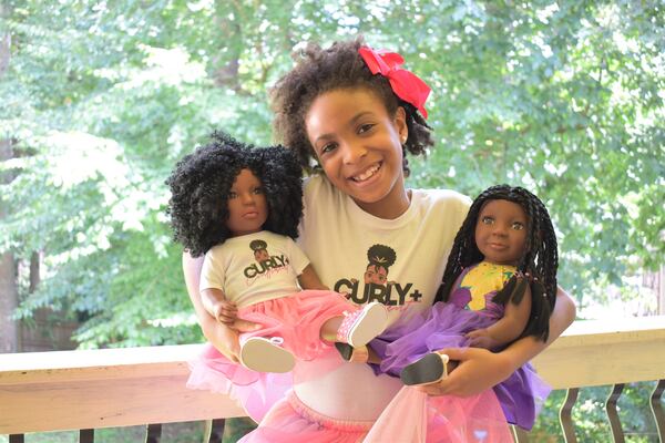 Zoe Oli holds two of her Beautiful Curly Me dolls. Courtesy of Evana Oli