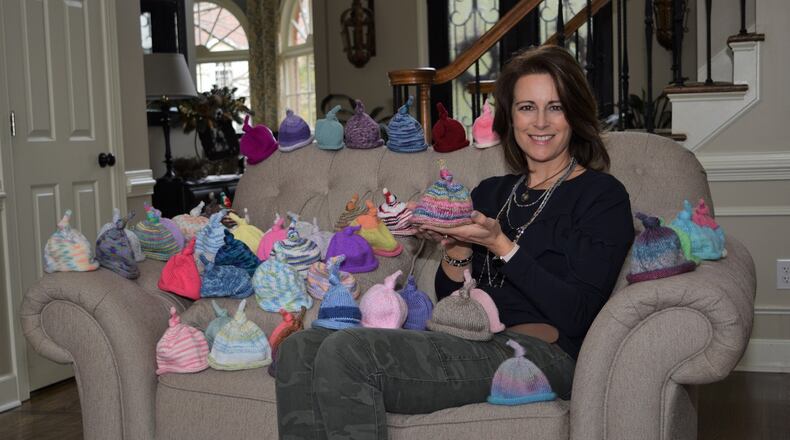 Surrounded by the 52 preemie baby caps that she knitted last year for her New Year’s resolution, Amy Scutt follows the example set by the late Ed Mosely of Acworth. Marty Farrell for the AJC