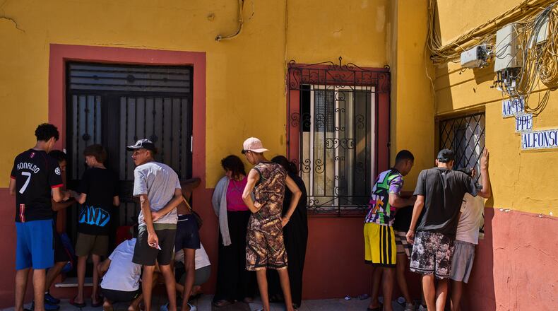 Migrants, some of them unaccompanied minors, who crossed from Morocco into Spain, write down their contact information to give to a neighborhood association in the Spanish enclave of Ceuta, Tuesday, Aug. 4, 2026. (AP Photo/Bernat Armangue)