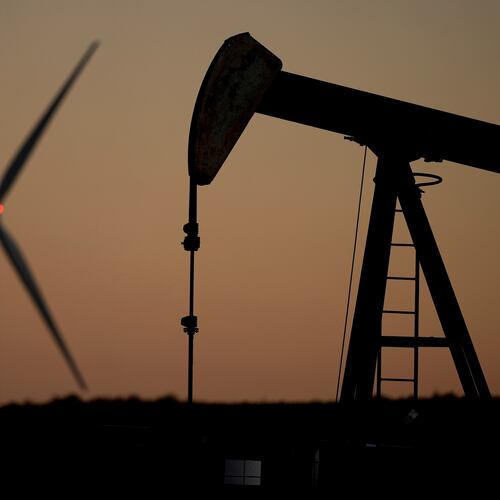FILE - A pumpjack operates in the foreground while a wind turbine at the Buckeye Wind Energy wind farm rises in the distance, Sept. 30, 2024, near Hays, Kan. (AP Photo/Charlie Riedel, File)