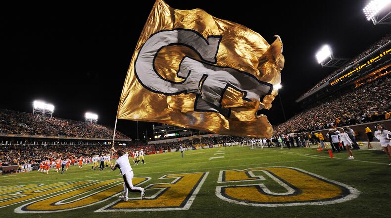 A Georgia Tech cheerleader carries a GT flag on the field after Georgia Tech scored a touchdown against Clemson at Georgia Tech on Saturday, Oct 29, 2011. Johnny Crawford / AJC file