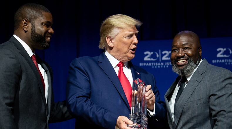 President Donald Trump is presented an award by Byron Donalds, left, and Matthew Charles, before addressing the 2019 Second Step Presidential Justice Forum at Benedict College in Columbia, S.C. on Friday, Oct. 25, 2019. (Erin Schaff/The New York Times)