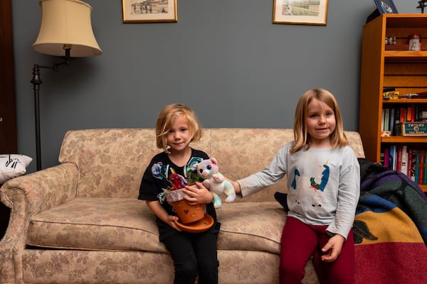 Sarah Eldridge’s daughters, Isabelle and Elena, sit on a couch in their home in Knoxville, Tenn., on Tuesday, Oct. 29, 2025. Isabelle holds a pot she decorated. (Courtesy of Jared Worsham)
