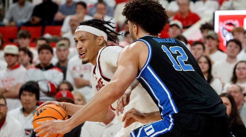 North Carolina State's Darrion Williams, left, tries to drive the ball around Duke's Cameron Boozer (12) during the first half of an NCAA college basketball game in Raleigh, N.C., Monday, March 2, 2026. (AP Photo/Karl DeBlaker)