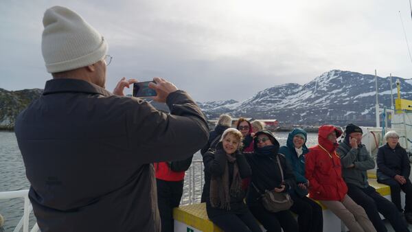 Tourists on a whale watching boat tour take photos at sea near Nuuk, Greenland, Tuesday, June 17, 2025. (AP Photo/Kwiyeon Ha)
