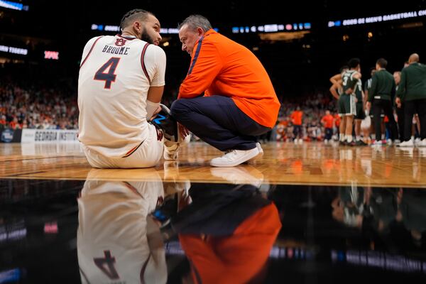 Auburn forward Johni Broome (4) is helped on the court during the second half in the Elite Eight of the NCAA college basketball tournament against Michigan State, Sunday, March 30, 2025, in Atlanta. (AP Photo/George Walker IV)