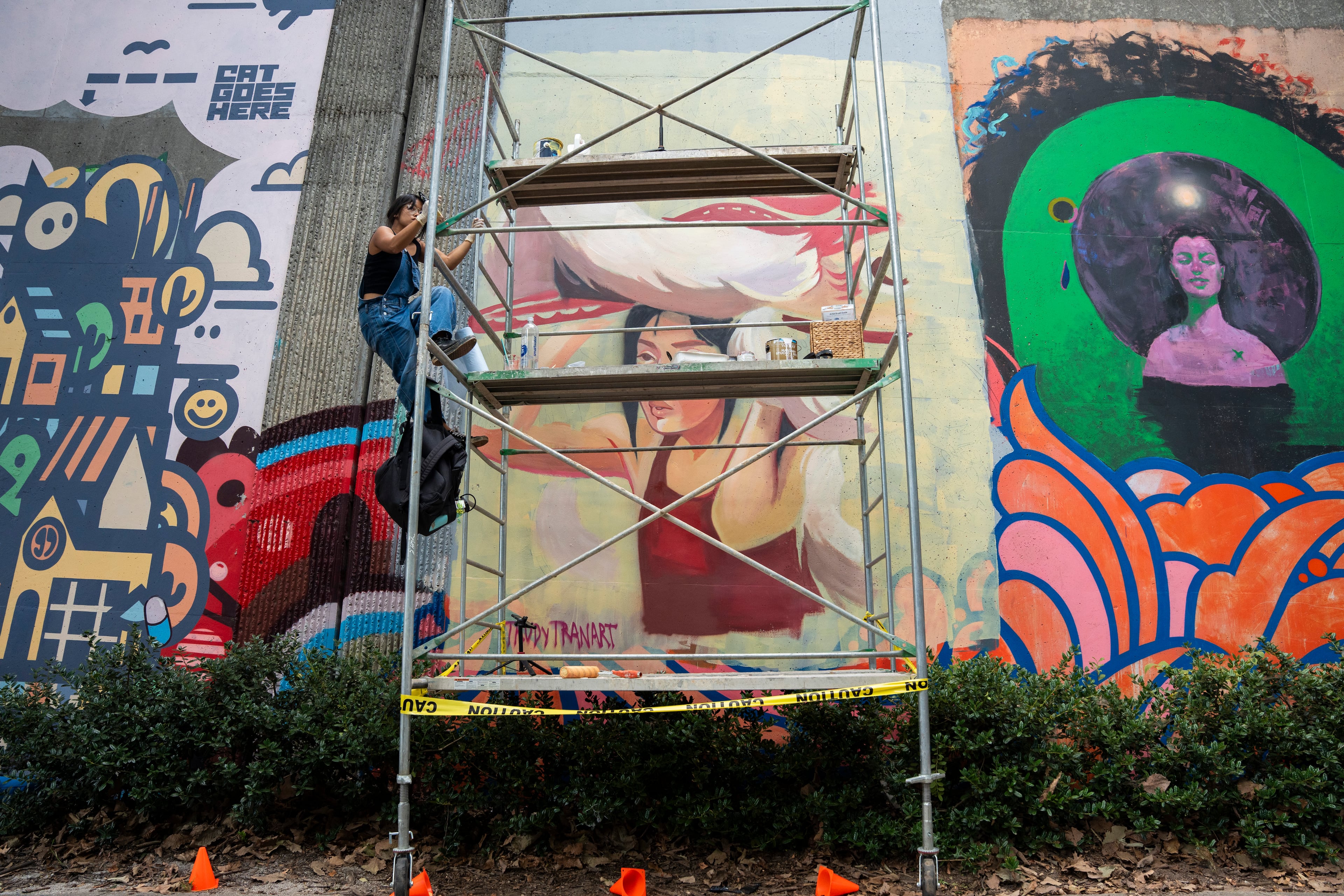 Local artist Trudy Tran paints climbs scaffolding to paint a mural at the 11th annual Forward Warrior festival in the Cabbagetown neighborhood of Atlanta on Saturday, Sept. 13, 2025. (Olivia Bowdoin for the AJC)