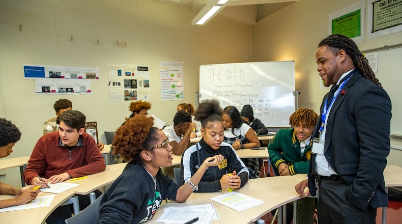 Kelsey Allen, front left, talks with her teacher, Rashad Brown, in their Advanced Placement African American Studies at Maynard Jackson High School on Friday, Feb 17, 2023.  (Jenni Girtman for The Atlanta Journal-Constitution)