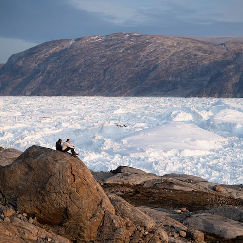 FILE - NYU student researchers sit on top of a rock overlooking the Helheim glacier in Greenland, Aug. 16, 2019. (AP Photo/Felipe Dana, File)