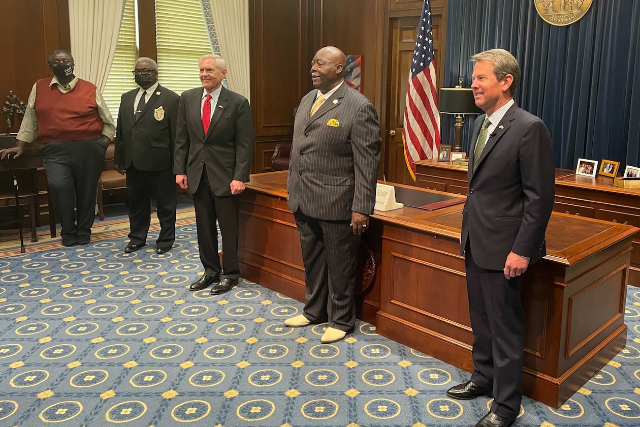Rev. Abraham Mosley, center, poses for a photo after being sworn in as the new board chair for the Stone Mountain Memorial Association. Georgia Gov. Brian Kemp, right, and memorial association CEO Bill Stephens, left, were also present. GREG BLUESTEIN / GREG.BLUESTEIN@AJC.COM
