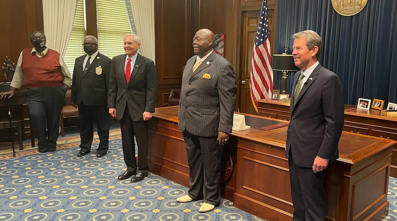 Rev. Abraham Mosley, center, poses for a photo after being sworn in as the new board chair for the Stone Mountain Memorial Association. Georgia Gov. Brian Kemp, right, and memorial association CEO Bill Stephens, left, were also present. GREG BLUESTEIN / GREG.BLUESTEIN@AJC.COM