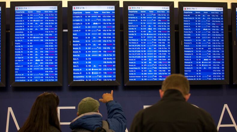 Travelers monitor the boards at Hartsfield-Jackson Atlanta International Airport, Friday, Jan. 6, 2017, in Atlanta. Delta canceled about 350 flights due to inclement weather. BRANDEN CAMP/SPECIAL