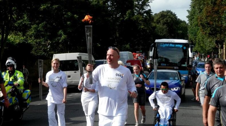 Jon McCullough, a two-time Paralympian and executive director of BlazeSports, carries the torch during the 2012 Summer Paralympics in London, England.