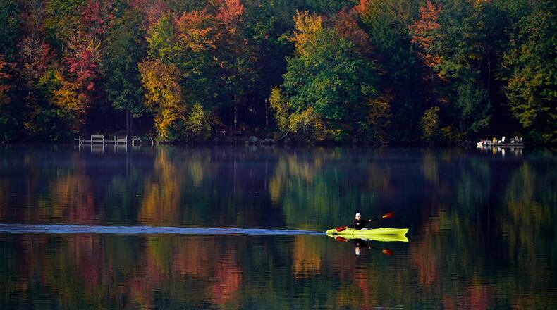 FILE - Virginia Davidson of Bridgton, Maine, paddles her kayak on Moose Pond, Oct. 13, 2021, in Bridgton, Maine. (AP Photo/Robert F. Bukaty)
