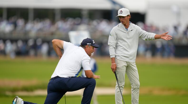 Miles Russell and Padraig Harrington, of Ireland, talk on the fourth hole during the first round of the U.S. Open golf tournament at Shinnecock Hills Golf Club in Southampton, N.Y., Thursday, June 18, 2026.(AP Photo/Seth Wenig)