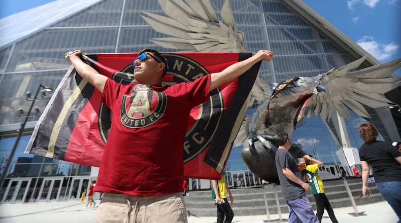 Manuel Garcia from Asheville North Carolina, shows he’s support with the Atlanta United flag in front of the eagle outside of the Mercedes-Benz Stadium on April 28, 2018.