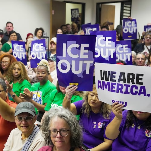 Community members hold signs reading "ICE Out" during a community vigil for Lorenzo Salgado Araujo in Houston on Saturday, July 11, 2026. (Raquel Natalicchio/Houston Chronicle via AP)