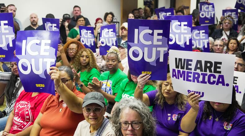 Community members hold signs reading "ICE Out" during a community vigil for Lorenzo Salgado Araujo in Houston on Saturday, July 11, 2026. (Raquel Natalicchio/Houston Chronicle via AP)