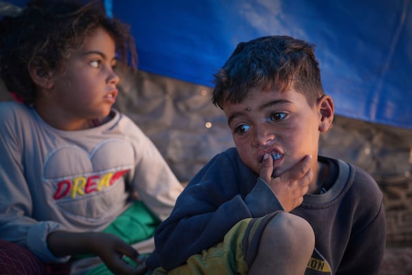 Raed Zaharna, right, and his sister Sally sit in their family tent after their mother, Ward, returned empty-handed from trying to receive donated food at a community kitchen in Khan Younis, in the southern Gaza Strip, Friday, May 9, 2025. (AP Photo/Abdel Kareem Hana)