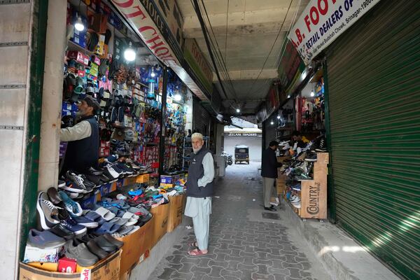 Kashmiri men purchase shoes inside the Auqaf Market in Srinagar, Indian controlled Kashmir, Wednesday, April 2, 2025. (AP Photo/Mukhtar Khan)
