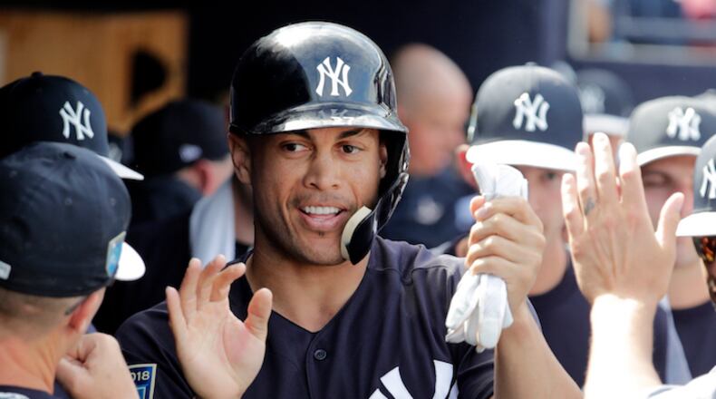 New York Yankees' Giancarlo Stanton is congratulated after scoring on a single hit by Didi Gregorius during the fifth inning of a baseball spring exhibition game against the Atlanta Braves, Friday, March 2, 2018, in Tampa, Fla. (AP Photo/Lynne Sladky)