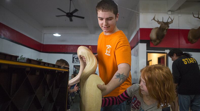 In this March 16, 2015 photo, Grant Thompson handles a large snake during a youth group's visit to Fish Bowl Pet Express in Temple, where Thompson was a senior staff member. Thompson, 18, died Tuesday, July 14, 2015, from an apparent snakebite after emergency medics found him in his car in North Austin.