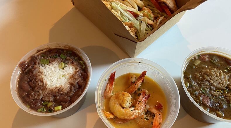 This to-go order from Lagarde in Chamblee includes a po’boy with fries, red beans and rice (left) plancha shrimp and gumbo. CONTRIBUTED BY BOB TOWNSEND