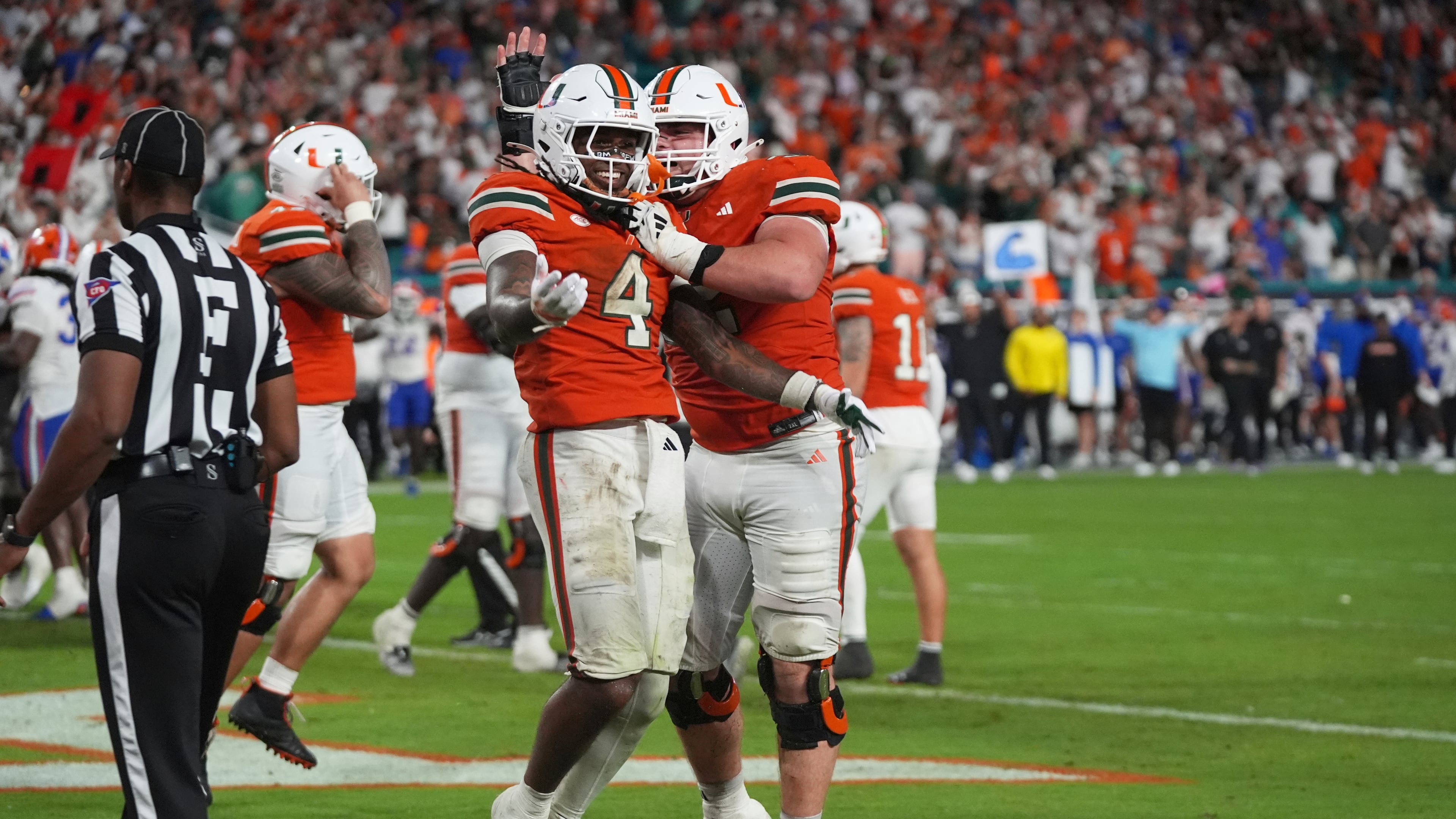 Miami running back Mark Fletcher Jr. (4) celebrates with offensive lineman James Brockermeyer, right, after scoring a touchdown during the second half of an NCAA college football game against Florida, Saturday, Sept. 20, 2025, in Miami Gardens, Fla. (AP Photo/Lynne Sladky)